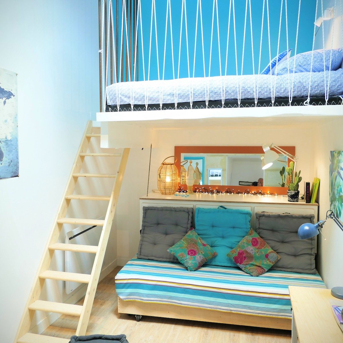 Un lit est aménagé en banquette la journée pour se poser, lire ou prendre l’apéritif. Le deuxième lit, en mezzanine, est accessible facilement par l’escalier.